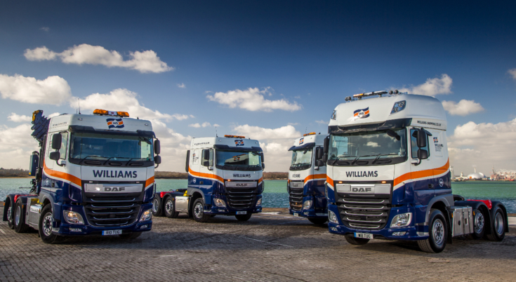A fleet of four Williams trucks featuring blue and orange part wrap designs provided by Elmtree Signs.
